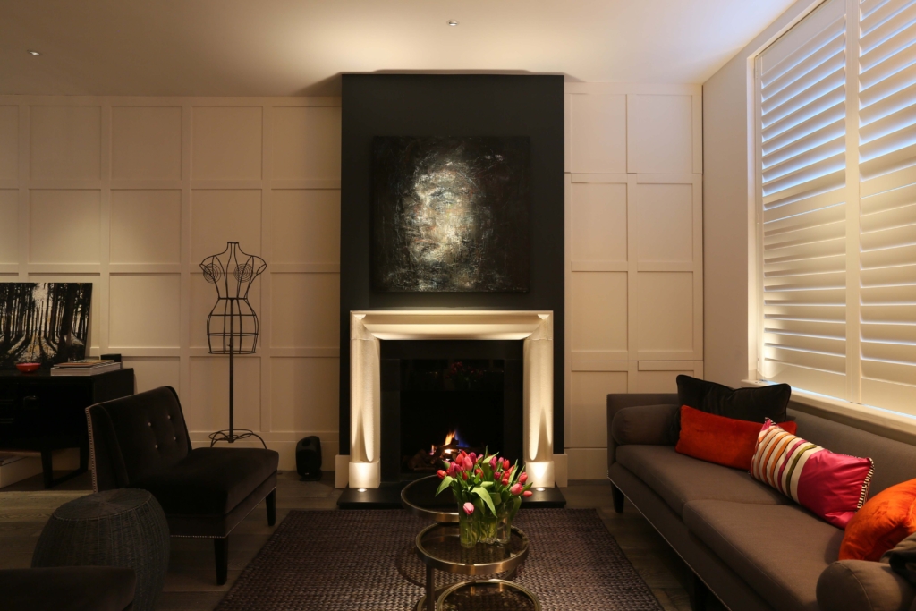 architectural lighting design for contemporary living room with uplit fireplace and art