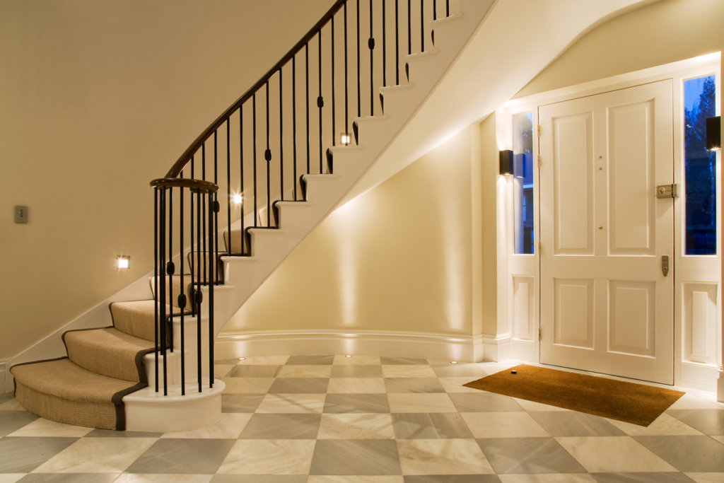 sweeping staircase with lighting underneath in hall