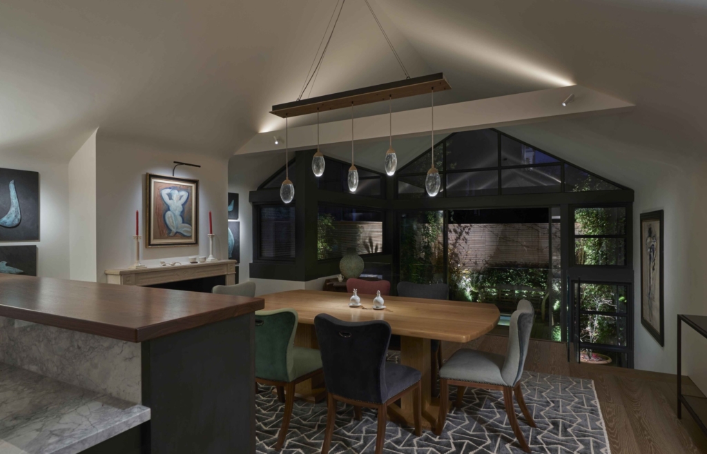 subtle lighting of view across dining room to garden beyond
