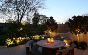 1 watt floodlights to the front of the tulips and two 1 watt spotlights to the small trees, plus a linear LED below the bench and candles on the table all create the mood in this outdoor dining area. 