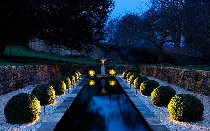 water feature lit with spike lights either side