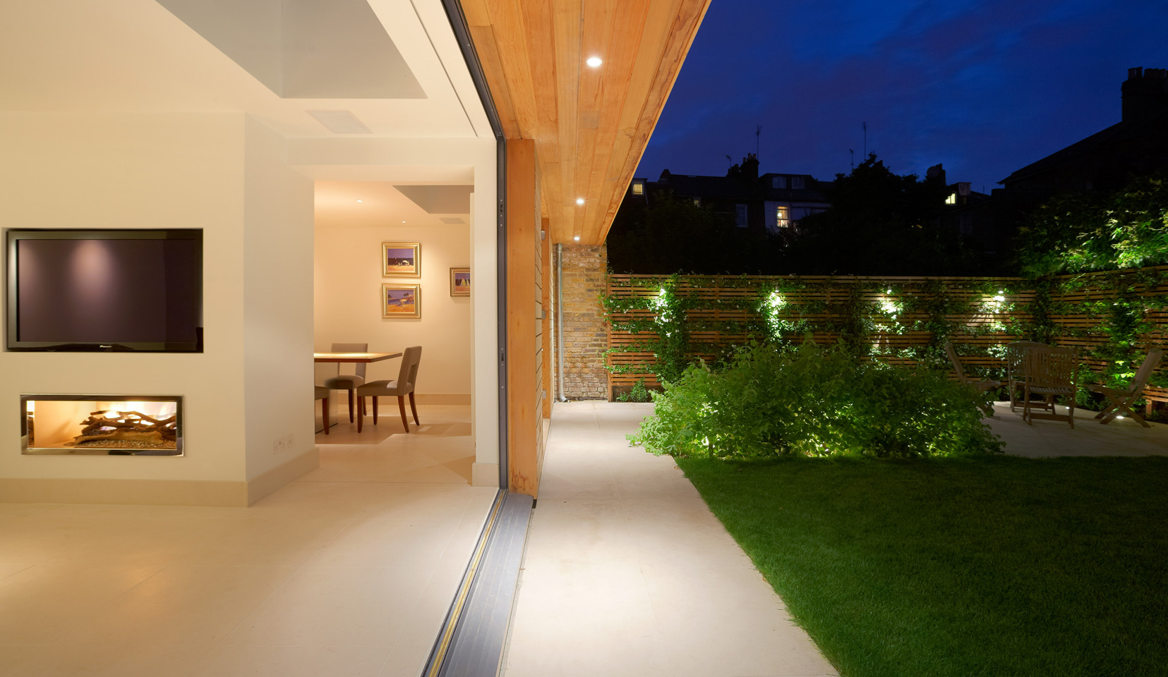 Open plan inside outside space with garden lighting and larg living area