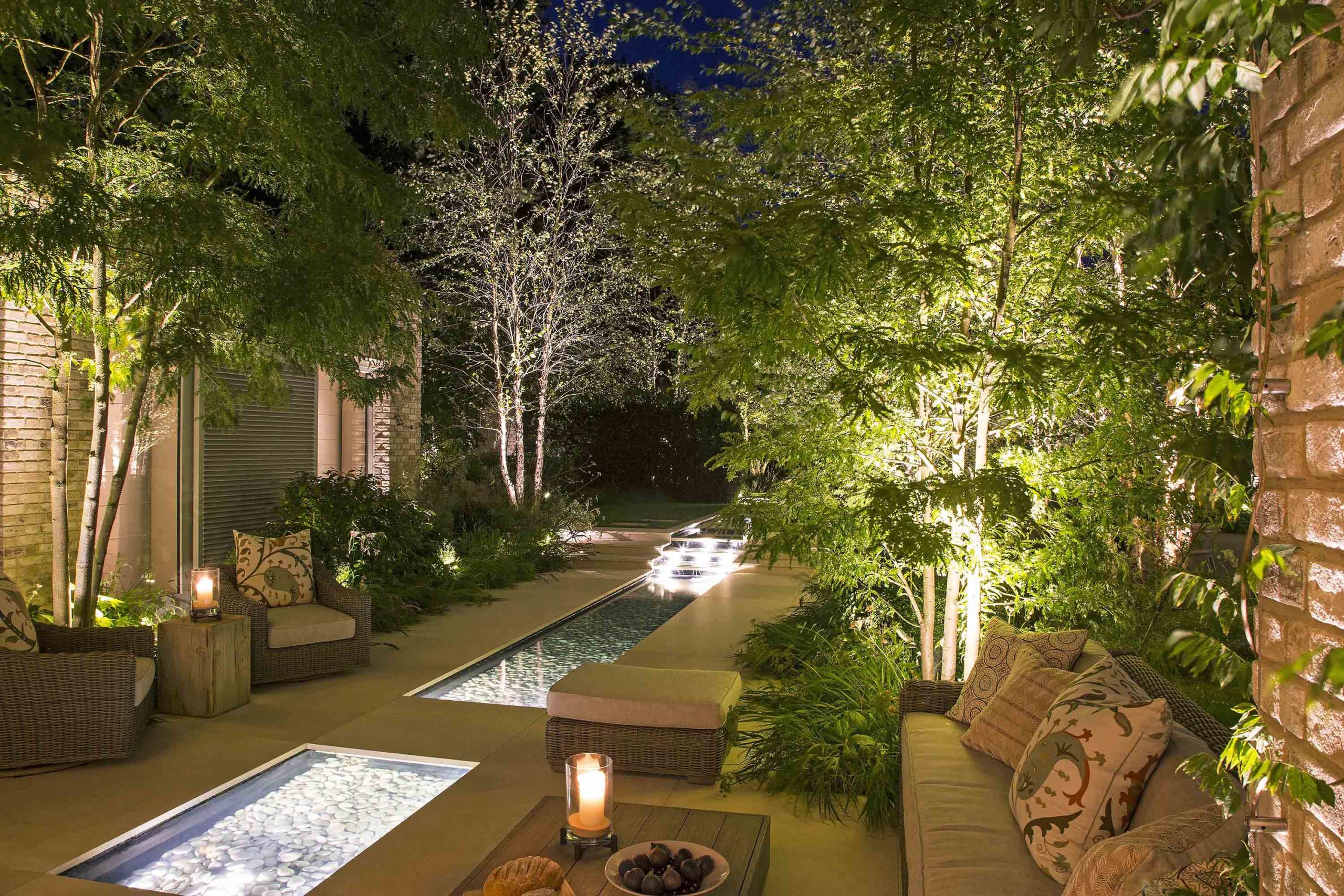 Water features in garden with underwater lights, and planting areas lit with spike lgihts