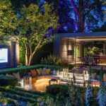 sunken garden with TV screen and uplit trees