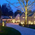 drive to country house with uplit wall and exterior