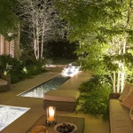 water rill with internal lighting surrounding by lit trees