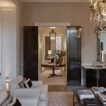 Living room with uplights to architectural details and view through to hallway