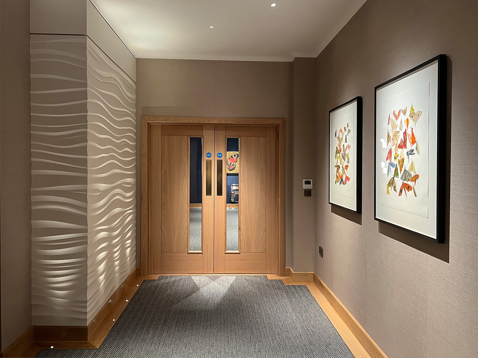 office circulation area with uplights to textured wall