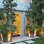 Front entrance with large plant pots uplit