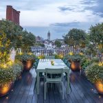 rooftop garden with table and uplit planters with soft planting