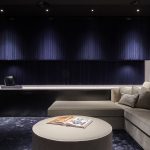 Media room with dark blue walls, sofa and luxurious artwork
