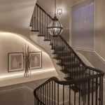 pendant hanging in traditional staircase with linear led strip behind