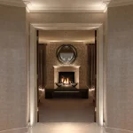 a wonderful corridor with uplights framing the door with a fireplace beyond in the centre with downlit niches either side