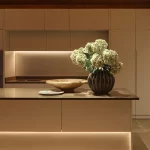 sleek kitchen with strong lines of light above and below the kitchen island