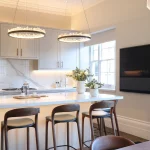 white kitchen with high ceiling and pendants over central island