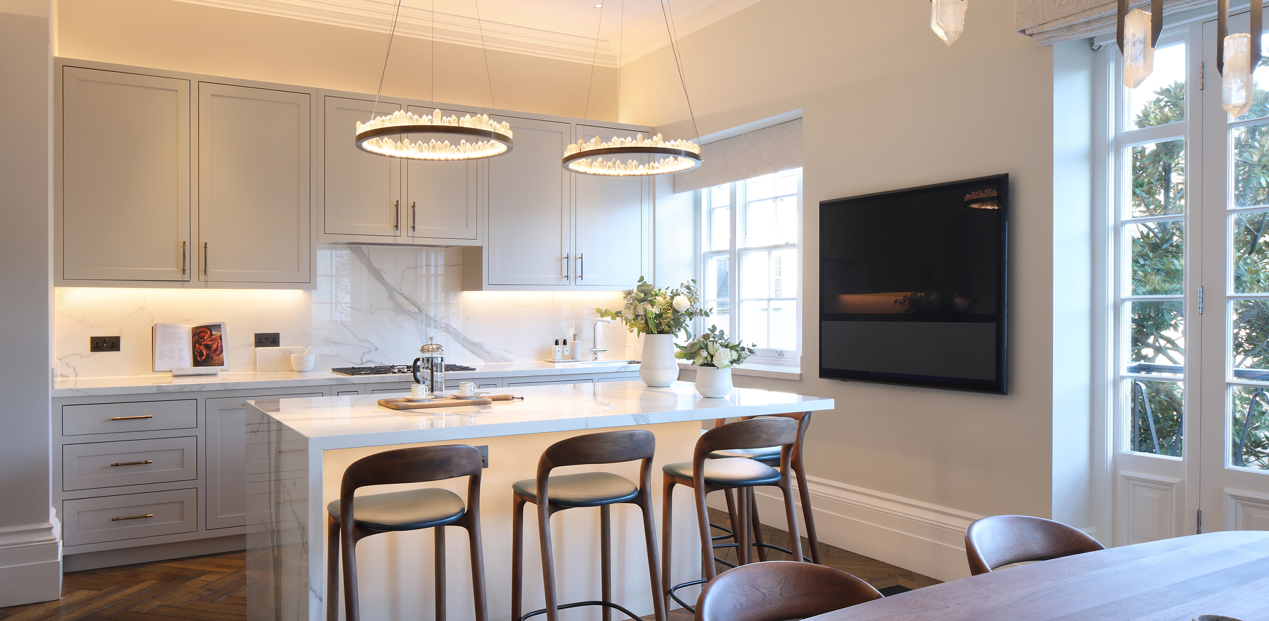 white kitchen with high ceiling and pendants over central island