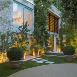 Entrance to new build house with large planter uplit in doorway