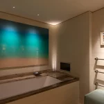 Bathroom with art above bath and directional downlights to light