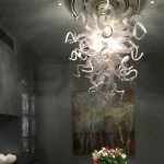 glass chandelier and downlights lighting down onto table