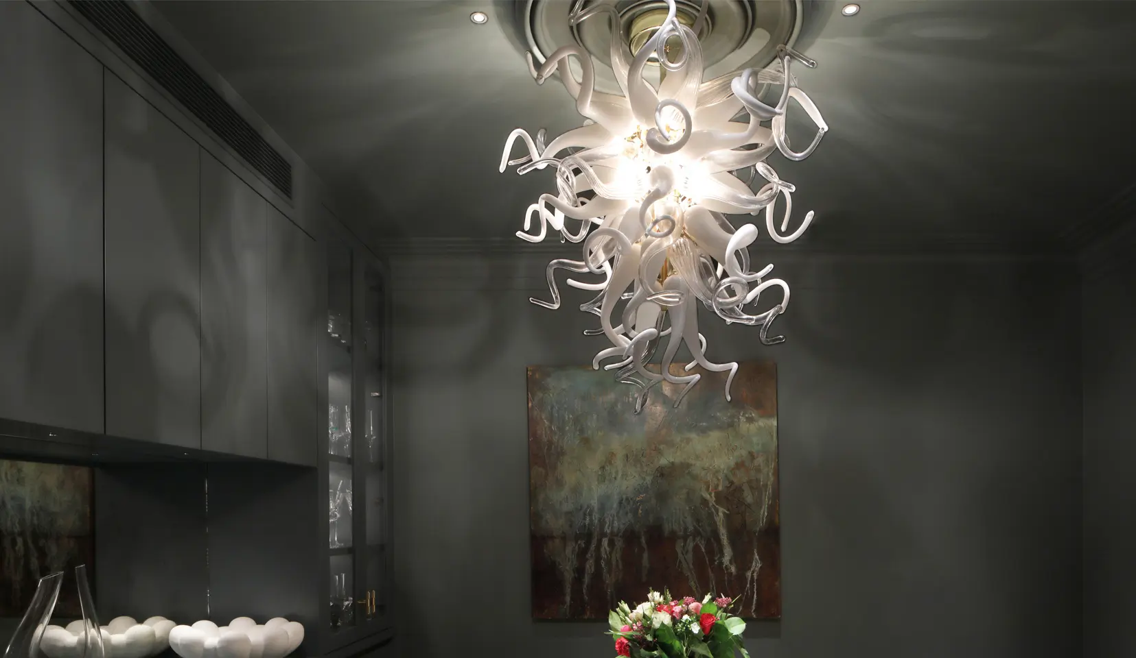 glass chandelier and downlights lighting down onto table