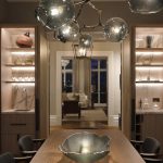 Joinery shelving with objects lit from behind with doorway leading to living room