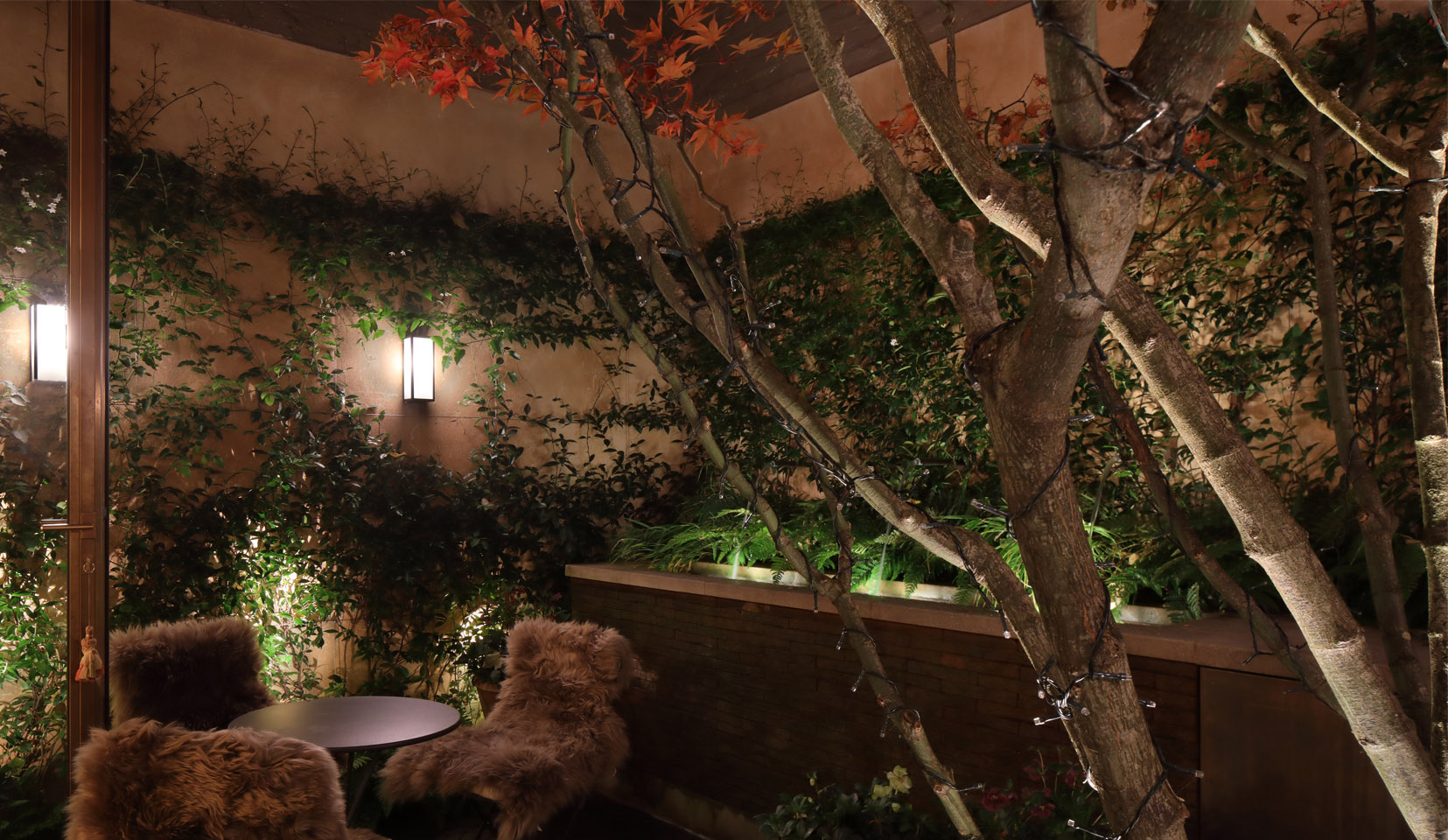 Small patio garden with table and chairs and wall mounted lighting