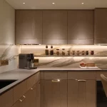 Kitchen units lit with downlights and under counter linear lighting onto kitchen surfaces