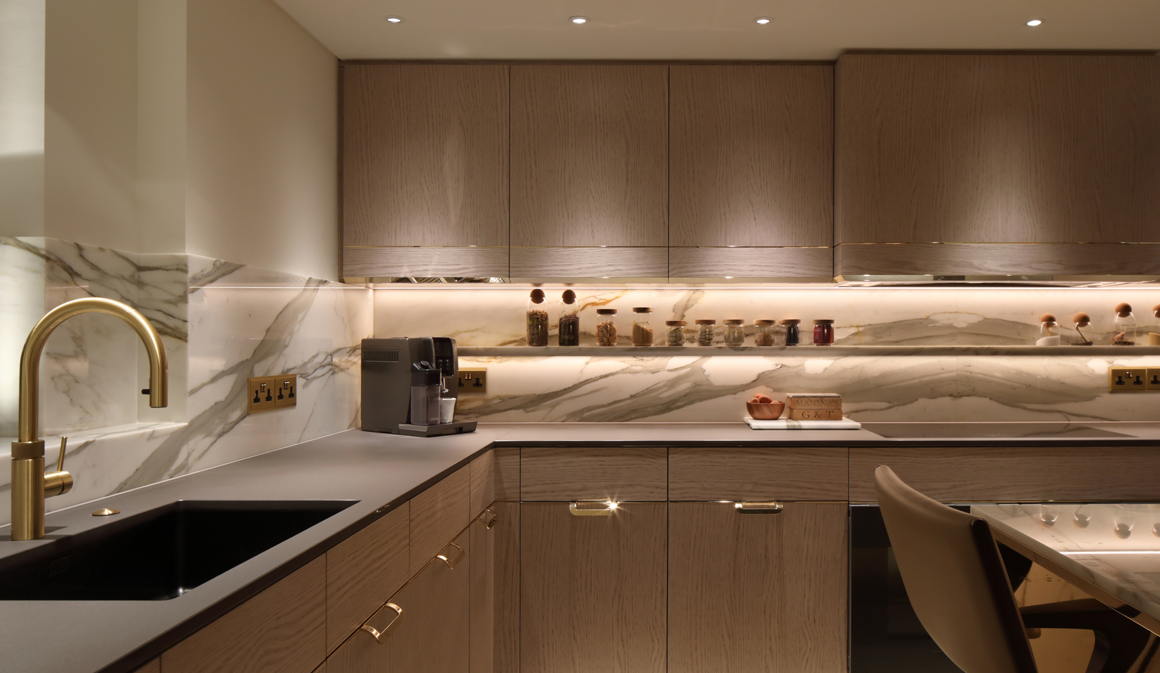 Kitchen units lit with downlights and under counter linear lighting onto kitchen surfaces