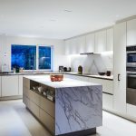 Brightly lit kitchen with marble island in centre