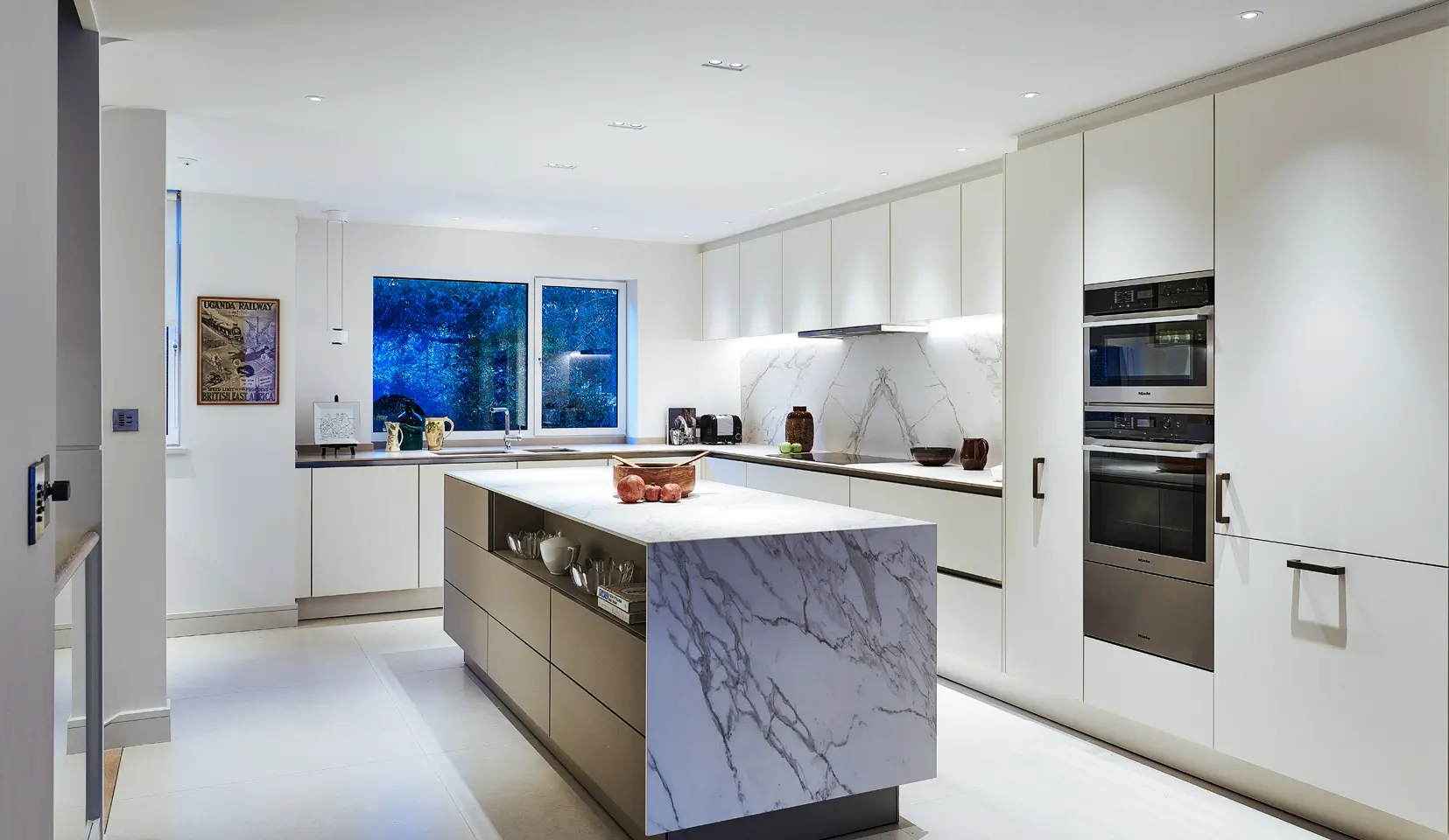 Brightly lit kitchen with marble island in centre
