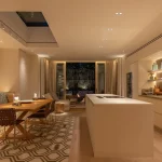 Open plan kitchen with island looking out through double doors to garden