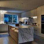 softly lit kitchen at dusk with marble island