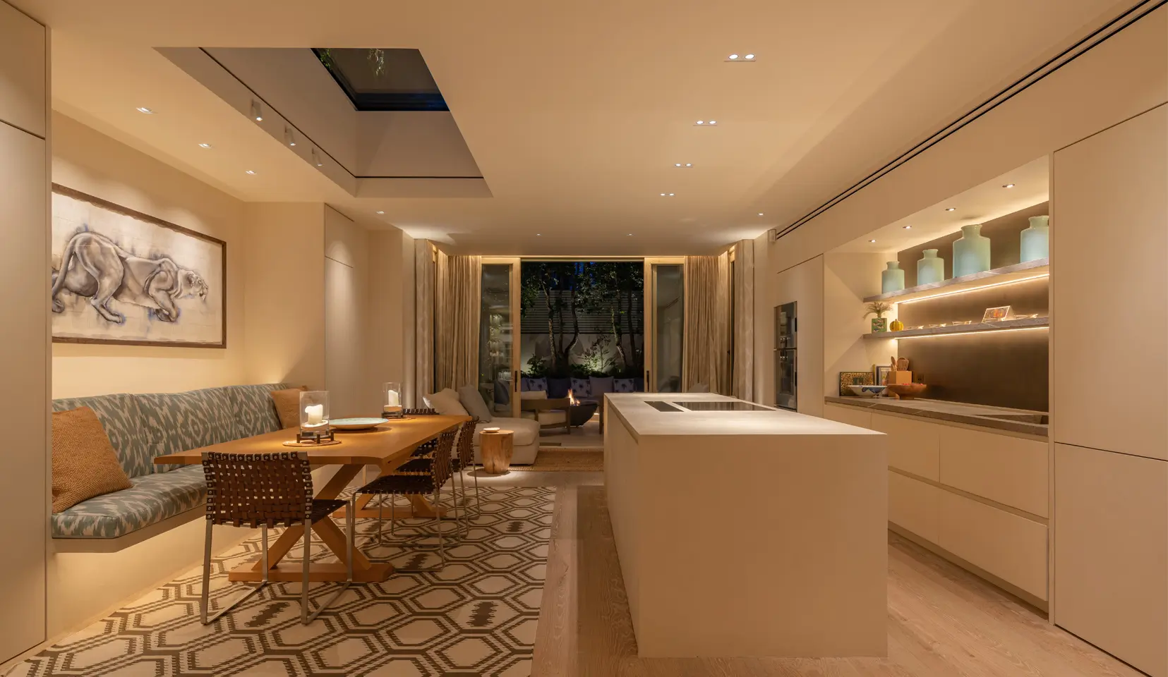 Open plan kitchen with island looking out through double doors to garden