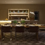 Dining room table with bar unit behind and moody evening lighting