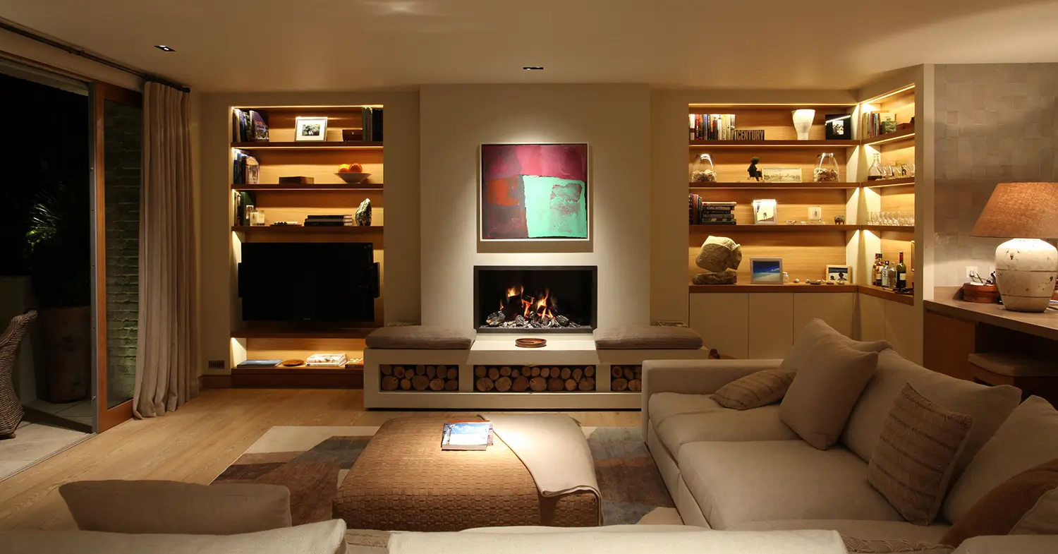 contemporary living room with open fireplace and book shelves either side and colour ful art