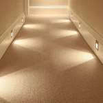 a long corridor with lights washing light across the floor creating patterns