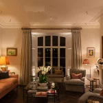 traditional living room with bold yellow art and uplit shutter box