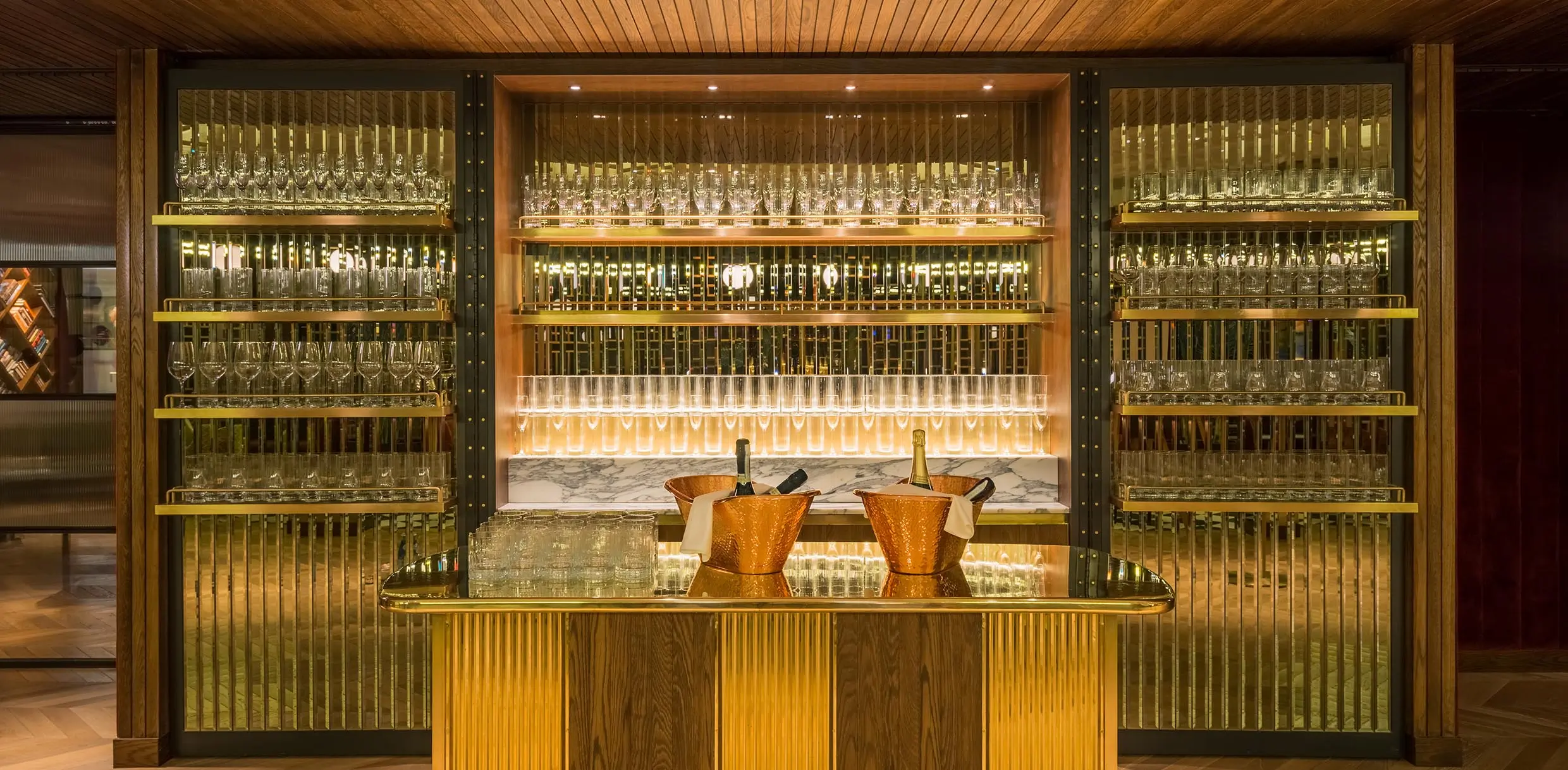 hotel bar with backlit glasses and champagne bottles on conter