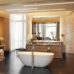 view into bathroom with freestanding bath and two mirror units with led strips in ceiling