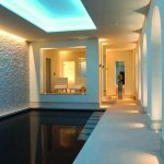 contemporary pool with slot of light down the back wall and lit corridor alongside