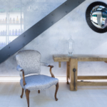 View below stairs with chair and table and backlit wall