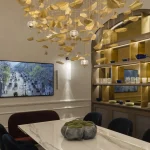 Dining room with lit shelving unit and hanging gold pendant