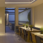 contemporary dining area with light behind banquette