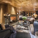 chalet living room with traditional wooden ceilings and open fireplace