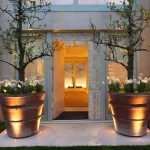 uplit overscaled pot with planting either side of a front door