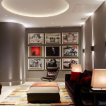 private cinema room with coffer ceiling and uplit curved walls with bank of U2 images at end