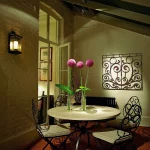 decorative lantern beside table with lit flowers and art