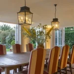 conservatory with over sized pendants and uplights behind planting