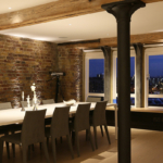 dining area of open plan wharf with uplit brick work