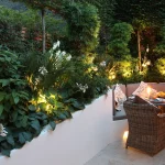 alfresco dining with underlit table and softly lit planting surrounding it